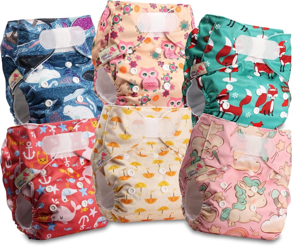 Stack of colourful washable cloth nappies for babies with cute prints and adjustable buttons